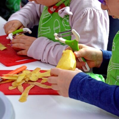 Dzieci obierają ziemniaki w prywatnym przedszkolu.