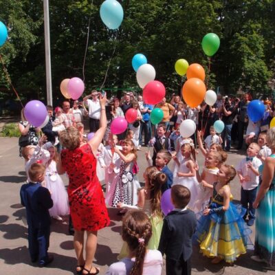 Dzieci wypuszczają balony w ramach uroczystości w prywatnym przedszkolu.