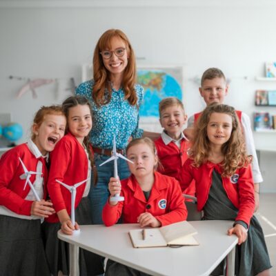 Grupa dzieci z nauczycielką w klasie w prywatnej szkole podstawowej.